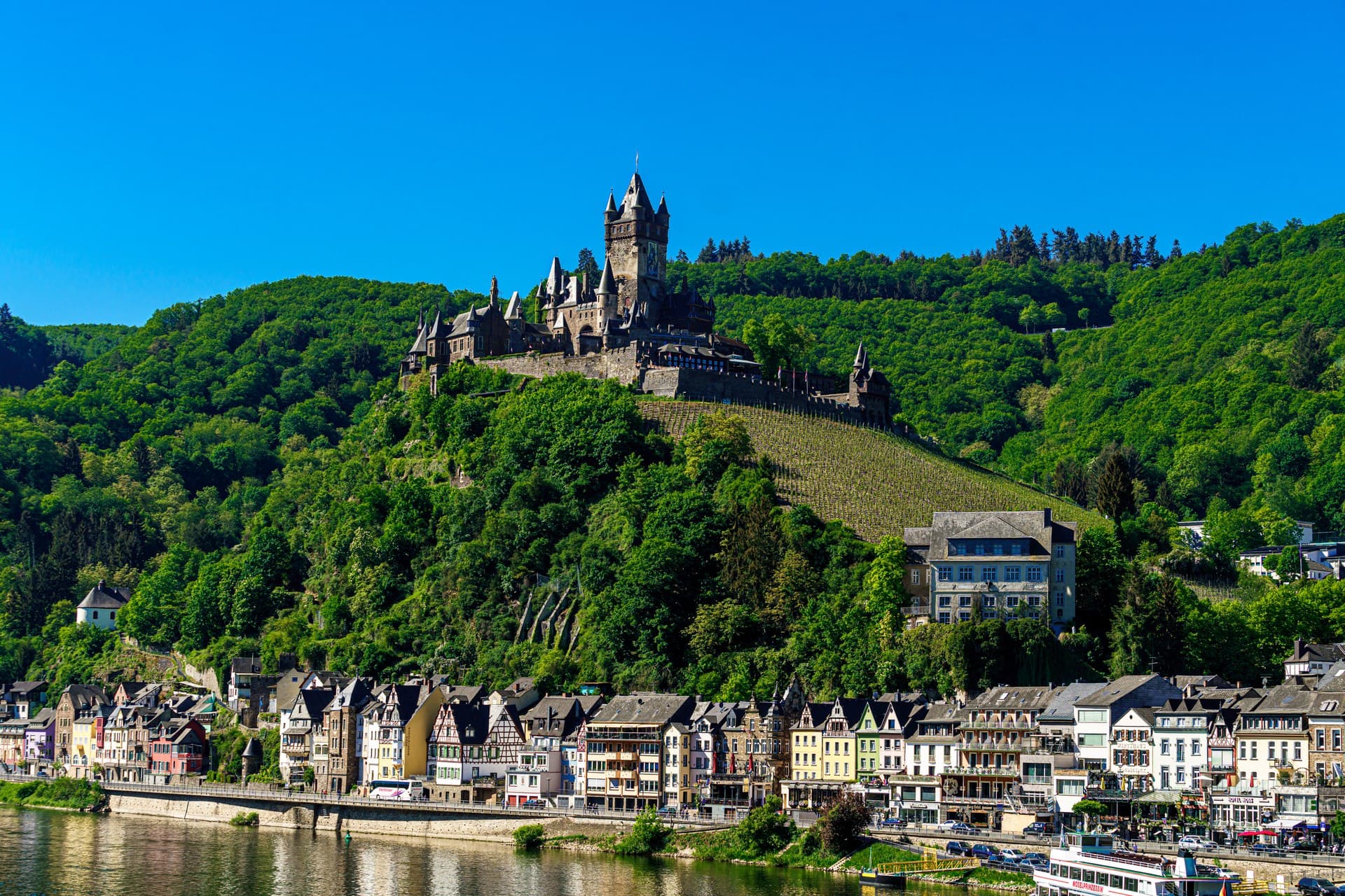 Reichsburg Cochem rising above the colourful waterfront of Cochem on the Moselle river