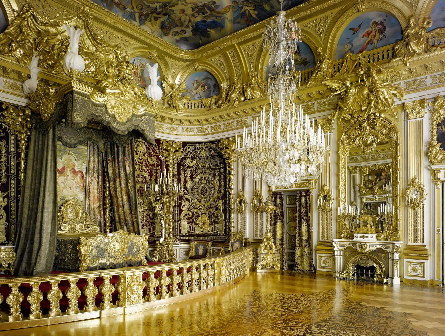 Herrenchiemsee New Palace 4 The State Bedchamber at Herrenchiemsee, richly decorated in red, blue, and gold with an ornate balustrade around the bed