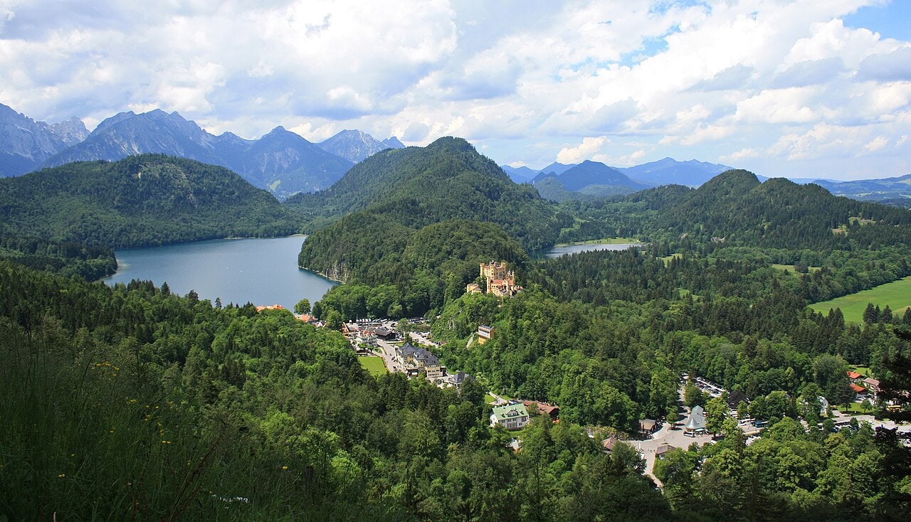 Best Castles in Bavaria 3 View from Neuschwanstein Castle across to Hohenschwangau Castle, with the Alpsee and Bavarian Alps beyond, Schwangau, Bavaria