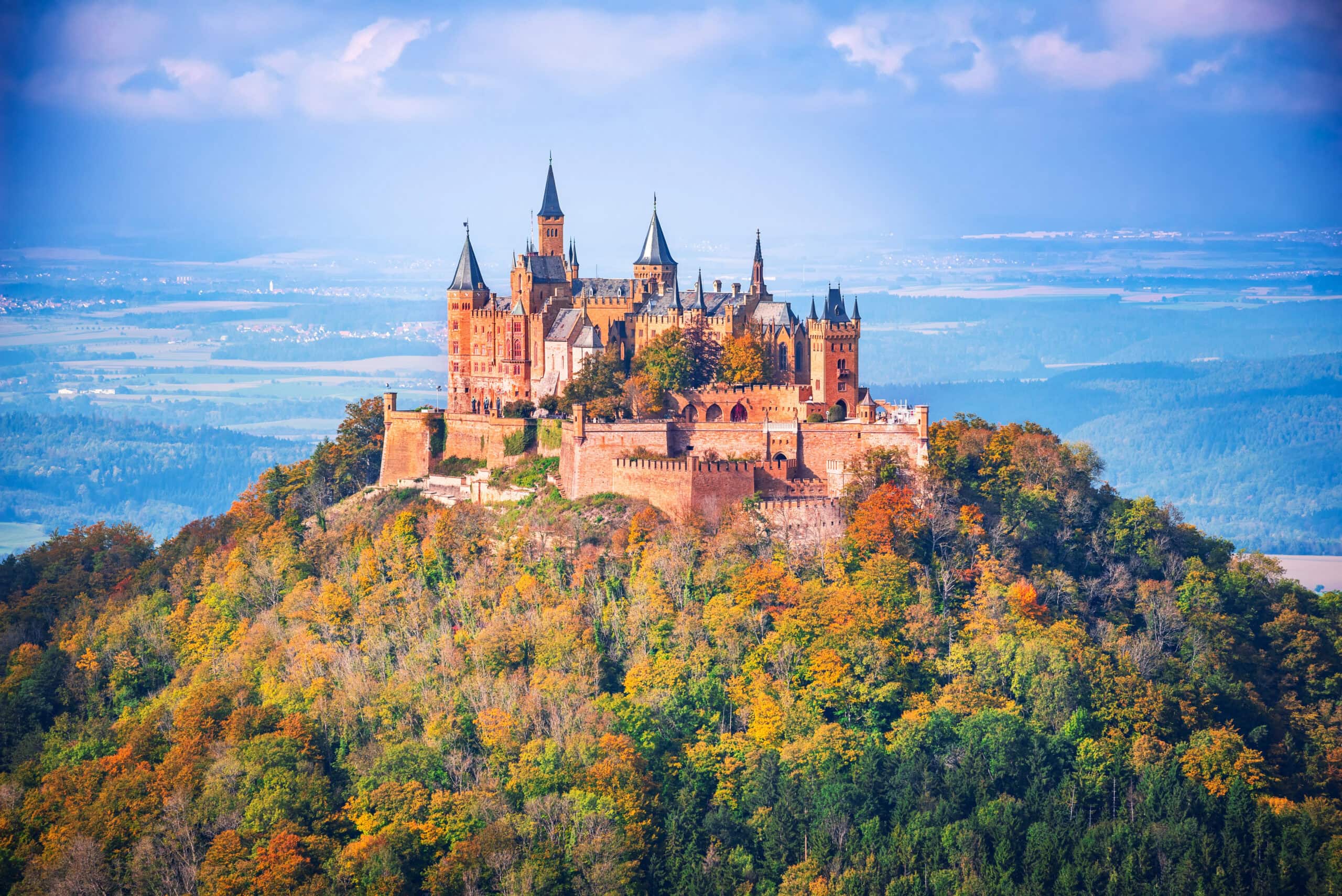 Hohenzollern Castle 1 Hohenzollern Castle on its isolated mountain cone in autumn, with the Swabian plain stretching to the horizon, Baden-Württemberg, Germany