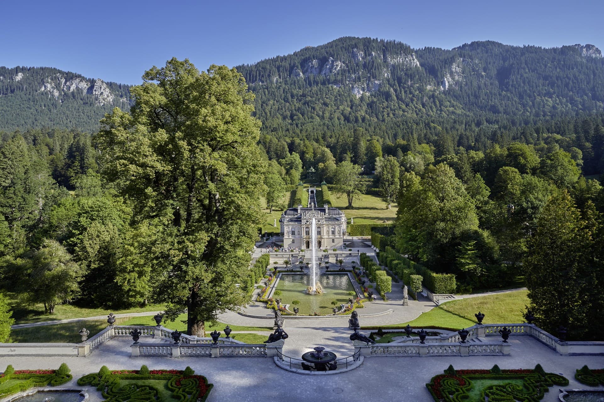 Best Castles in Bavaria 5 Linderhof Palace framed by the Ammergau Alps, viewed from the terrace gardens with the cascade and fountain jet