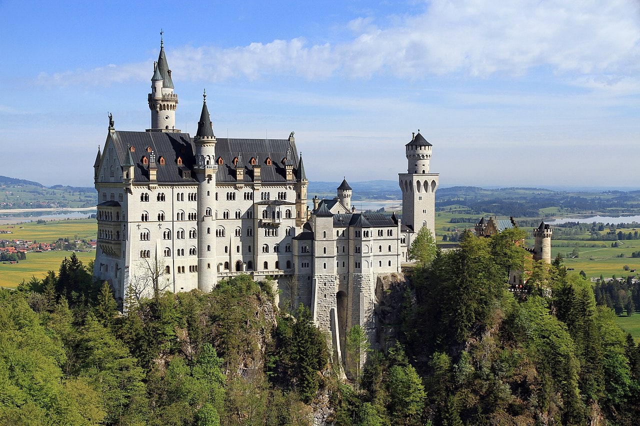 Neuschwanstein Castle 9 South facade of Neuschwanstein Castle viewed from the Marienbrücke footbridge in spring, with Lake Forggensee visible in the distance