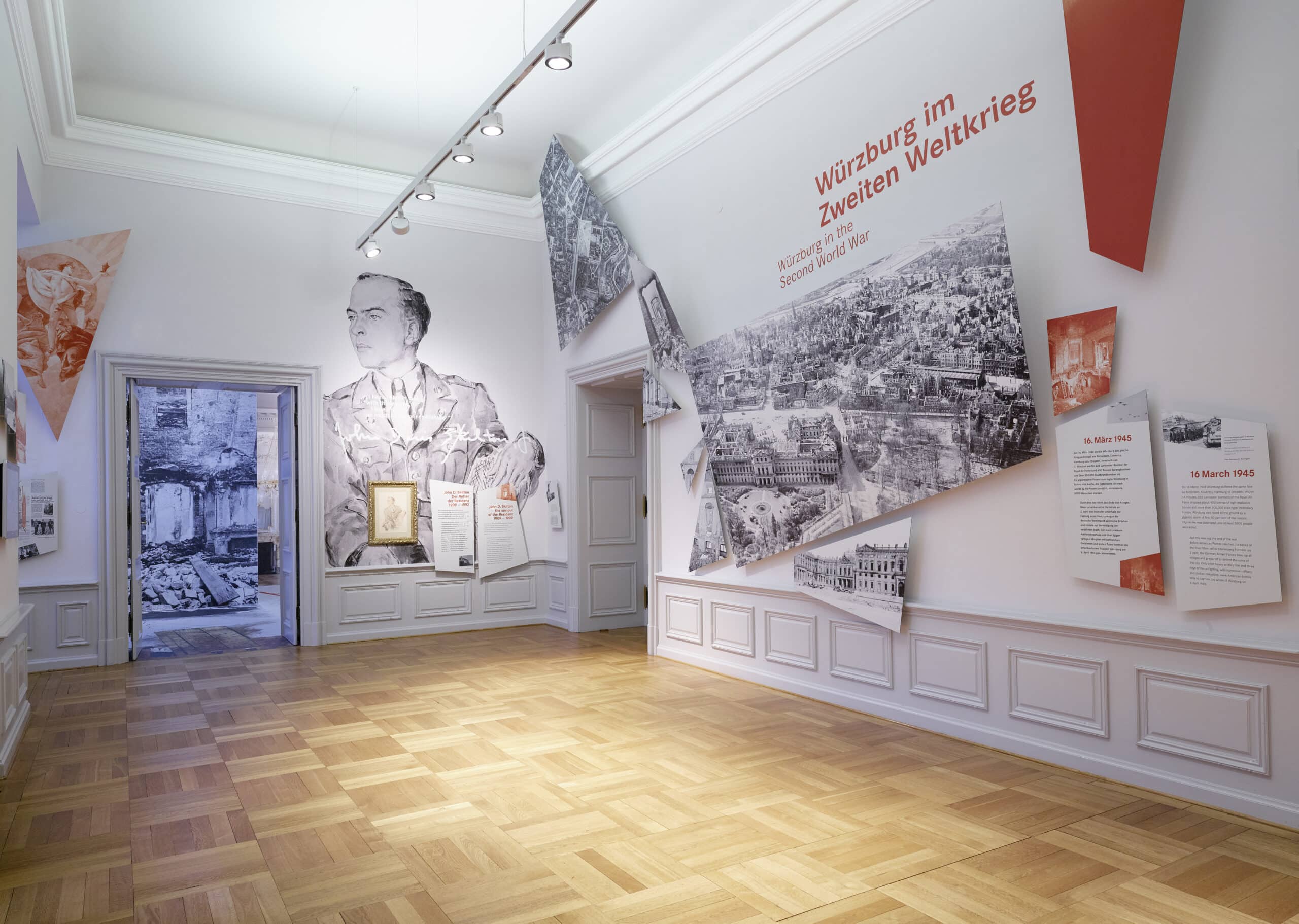 Würzburg Residence 6 The Gedenkraum at the Würzburg Residence with a wall portrait of Lieutenant John Davis Skilton Jr., aerial photographs of the destroyed city, and exhibit panels titled 'Würzburg im Zweiten Weltkrieg'.