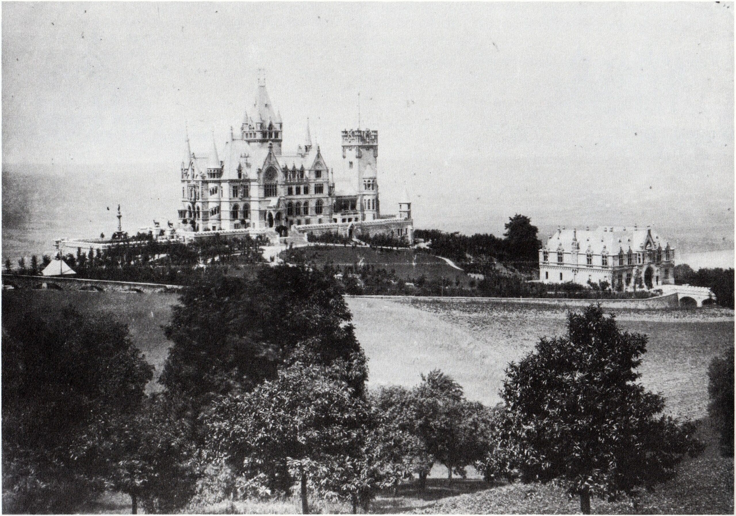 Drachenburg Castle 5 Black-and-white photograph from around 1900 showing Schloss Drachenburg from a distance with the Vorburg gatehouse visible at the right
