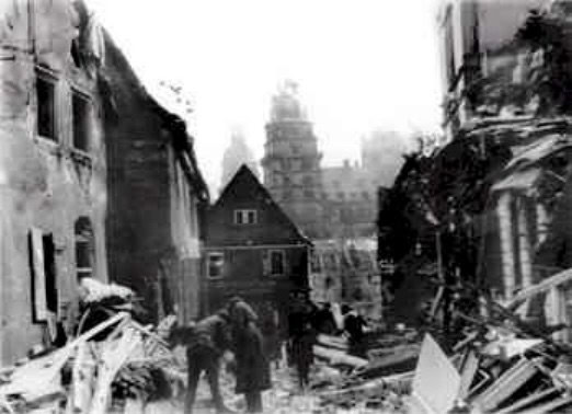 Johannisburg Palace 7 Black-and-white wartime photograph of Schloss Johannisburg as a ruined shell with collapsed walls, surrounded by rubble and debris.
