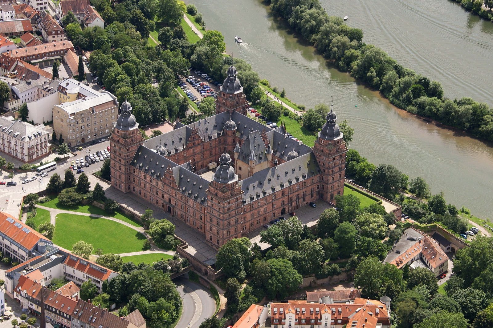 Best Castles in Bavaria 10 Aerial photograph of Schloss Johannisburg viewed from the east, showing the four-wing courtyard plan, four onion-domed corner towers, and the position of the Schloss between Aschaffenburg's old town to the north and the Main River to the east.