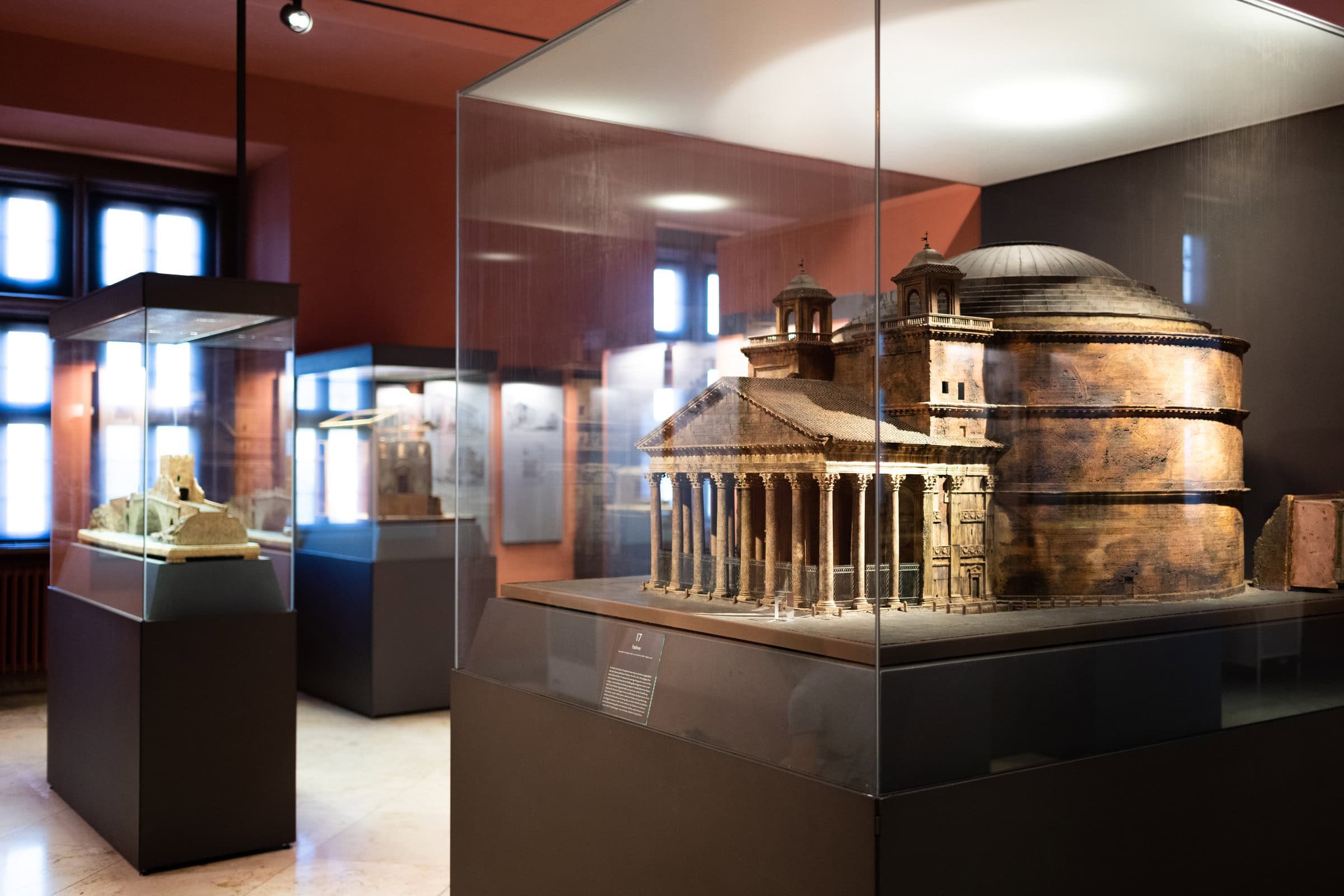 Johannisburg Palace 9 Museum display case containing a detailed cork model of the Roman Pantheon, with additional cork models visible behind glass in the background.