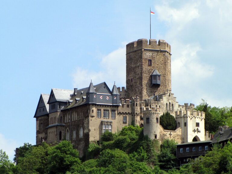 Home 4 Lahneck Castle bergfried and east curtain wall seen from below, with the medieval shield wall and pentagonal keep prominent