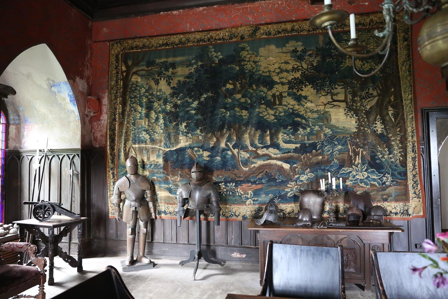 Lahneck Castle 7 Interior of the Rittersaal (knight's hall) at Lahneck Castle, with 16th- and 17th-century armor, polearms, a small cannon, and a wall tapestry, restored as a habitable Gothic-Revival residential room