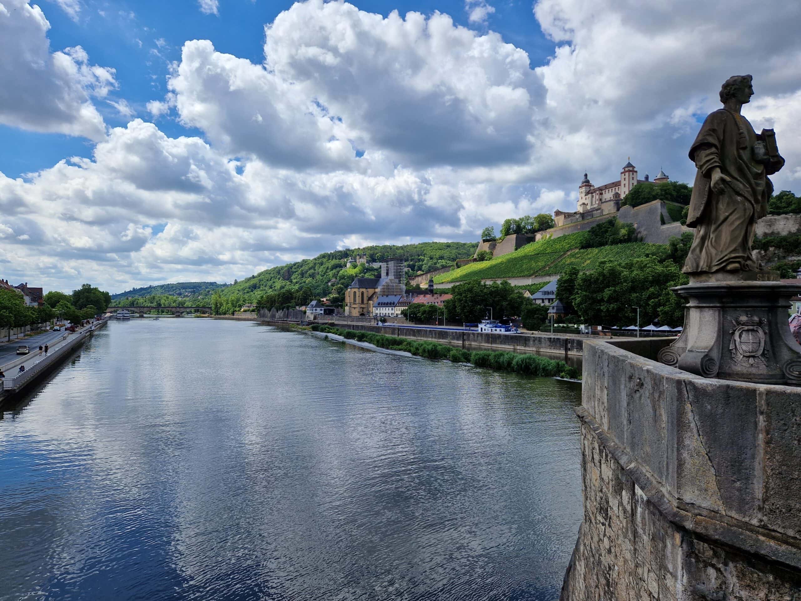 Best Castles in Bavaria 8 Marienberg Fortress seen from the Alte Mainbrücke, Würzburg, with the Main River and vineyards in the foreground