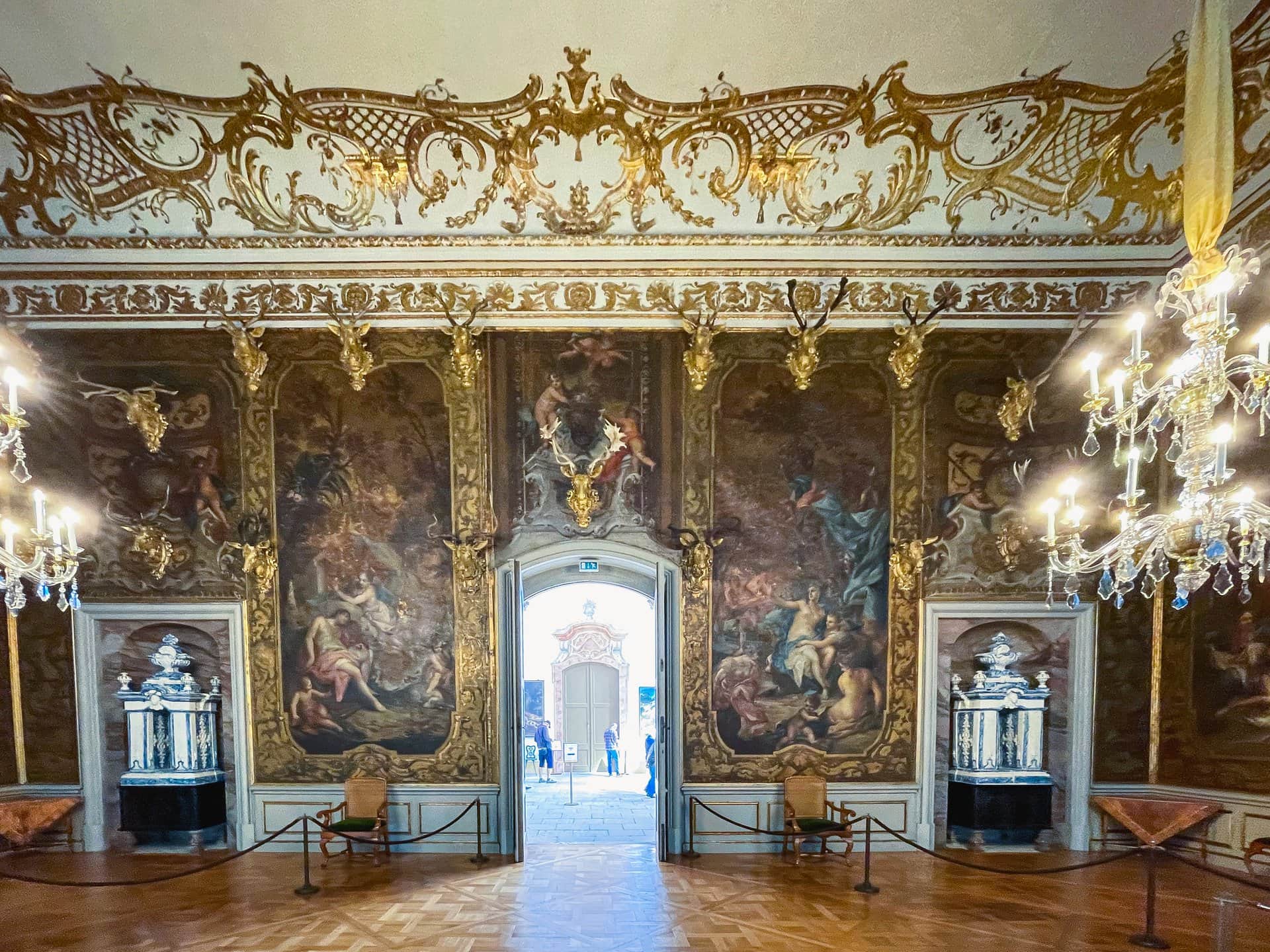 Moritzburg Castle 6 Interior of the Monströsensaal at Moritzburg Castle, with painted gilt-leather wall hangings, antler trophies, and crystal chandeliers