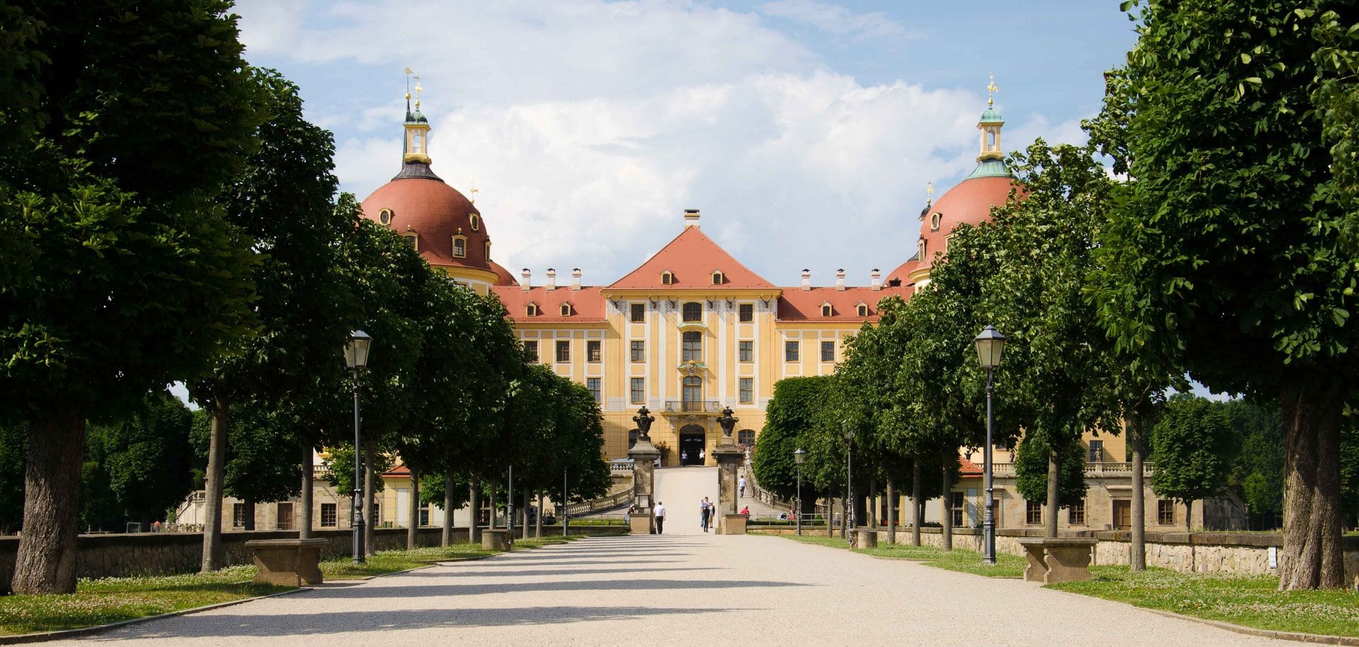 Moritzburg Castle 4 Wide view of Moritzburg Castle showing Pöppelmann's full Baroque facade with pink-orange render, four corner towers, and bell-curved cupolas