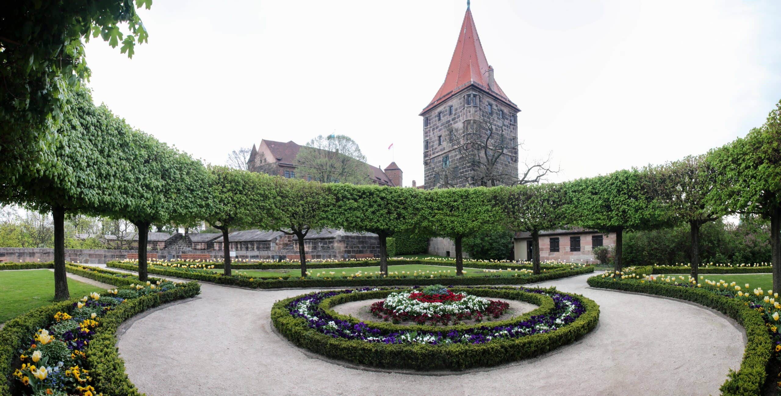 Nuremberg Castle 7 The Burggarten at Nuremberg Castle, a small flower-and-rose garden laid out on top of the sixteenth-century Burgbasteien, with the castle wall and Tiergärtnerturm visible in the background.