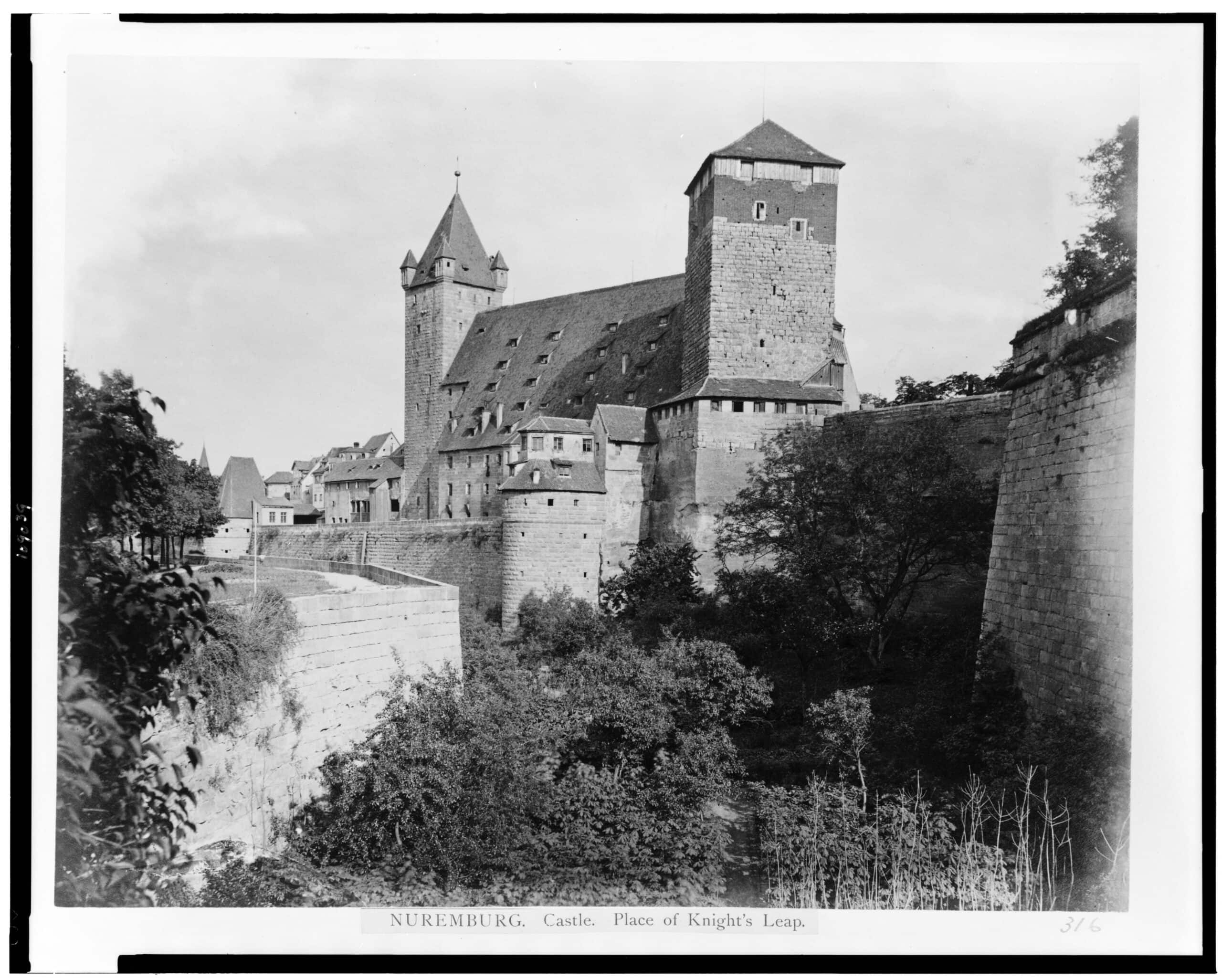 Nuremberg Castle 6 Black-and-white photograph from the Library of Congress collection captioned NUREMBURG. Castle. Place of Knight's Leap, showing the castle moat with the Luginsland tower, the Fünfeckturm, and surrounding structures before the Second World War.