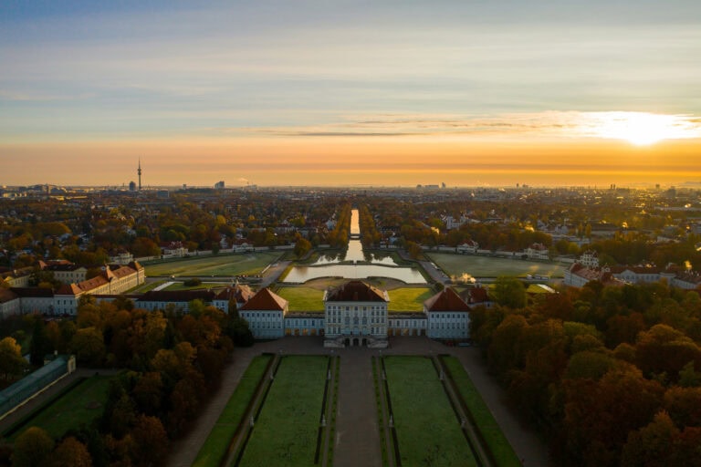 Nymphenburg Palace at sunset, aerial view along the canal axis with the central pavilion and park
