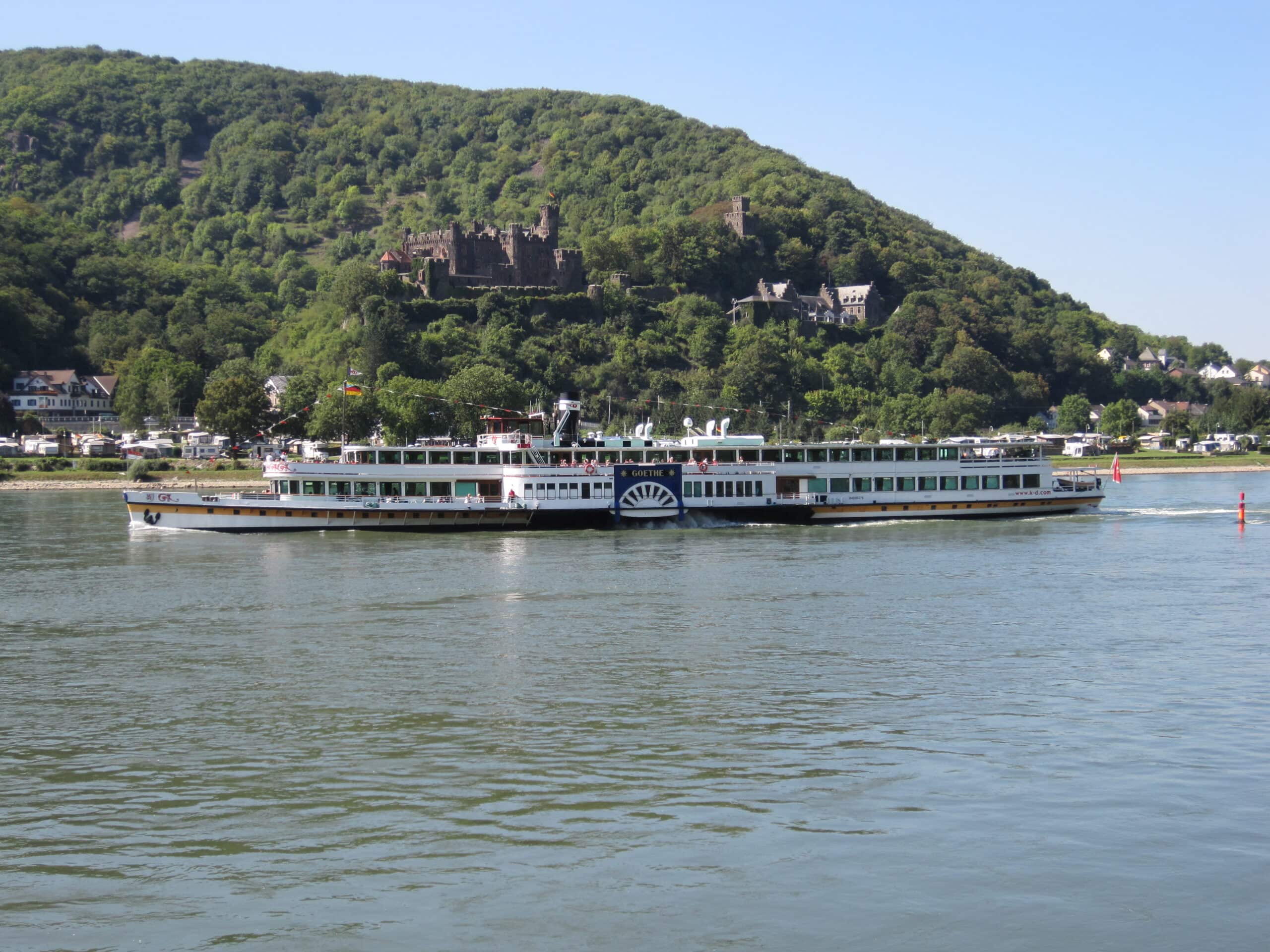 Reichenstein Castle 2 The Köln-Düsseldorfer paddle steamer Goethe rounding the Rhine bend below Reichenstein Castle at Trechtingshausen, with the castle on the wooded slope and the village campsite on the riverbank.