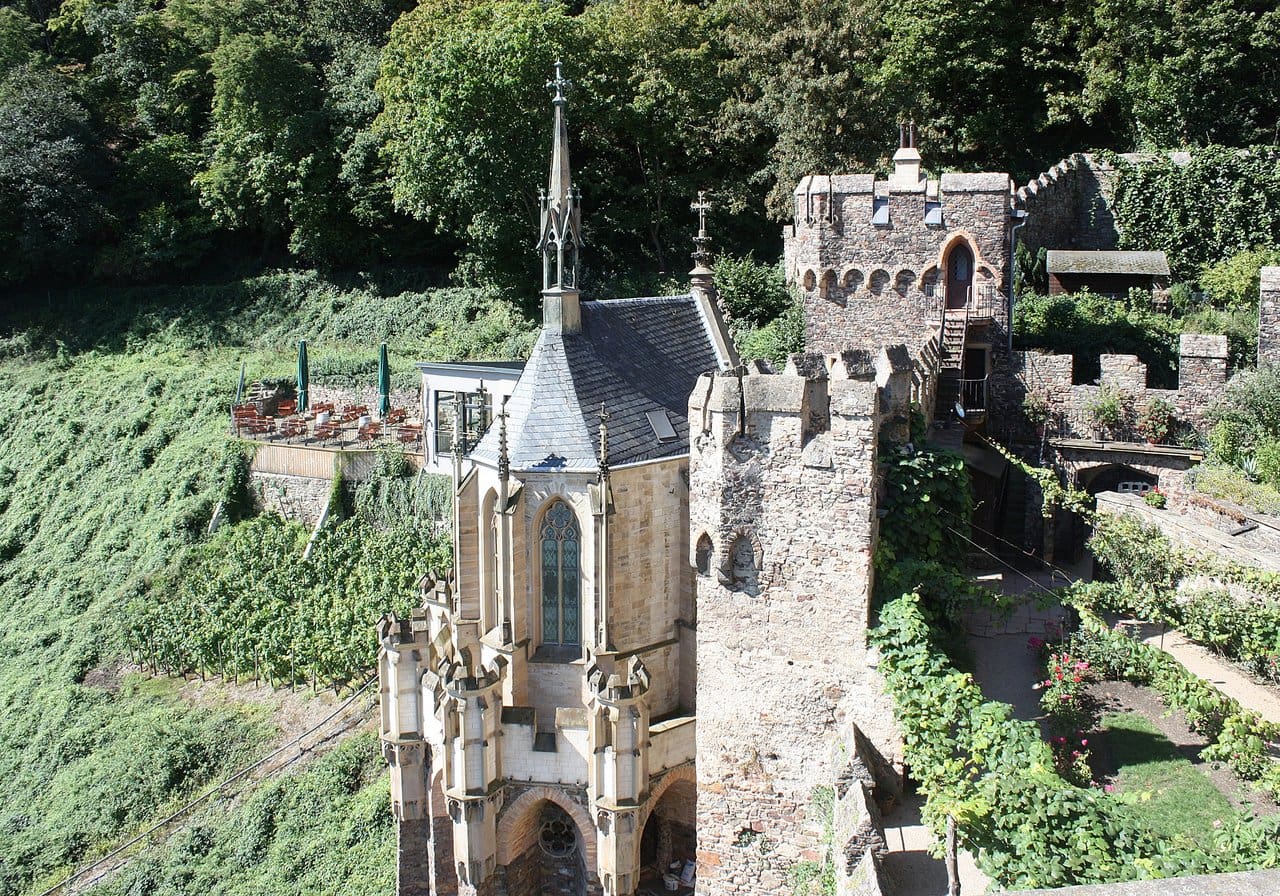 Rheinstein Castle 6 Aerial view of Rheinstein Castle's courtyard and the Burgundergarten, with the chapel at left, terraced paths, vines, and the restaurant terrace on the upper left.