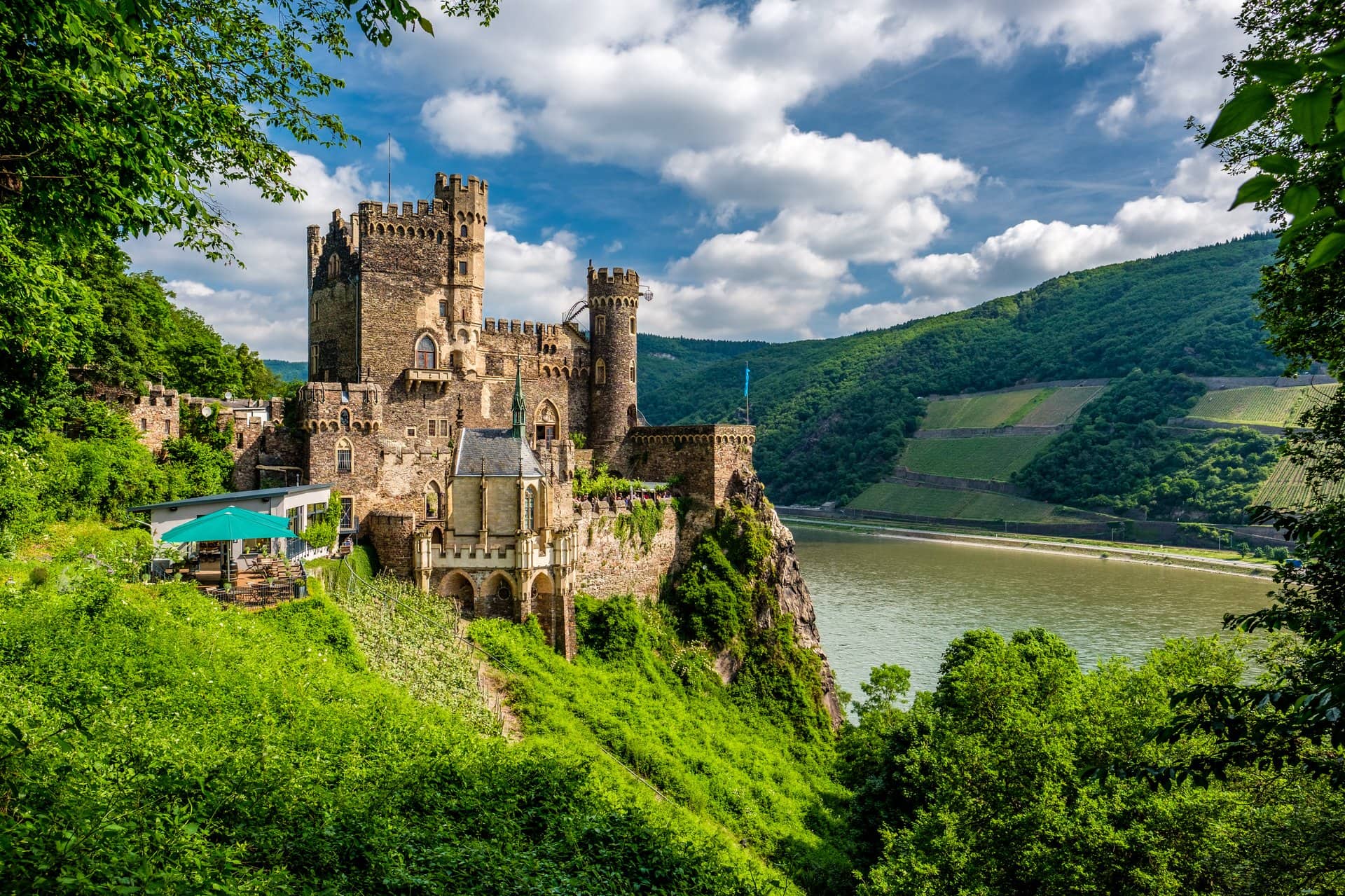 Rheinstein Castle 1 Rheinstein Castle perched above the Rhine with vineyards on the opposite bank, viewed from the south.