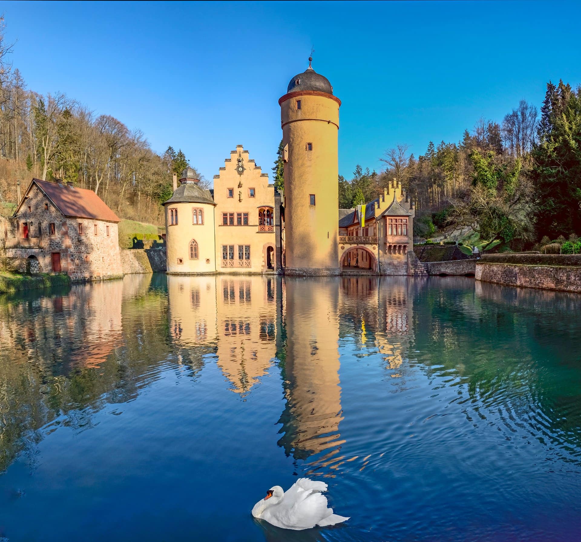 Best Castles in Bavaria 11 Schloss Mespelbrunn, the moated Renaissance Wasserschloss in a side-valley of the Spessart, viewed across the dammed Elsava brook with the round Bergfried tower rising at center between stair-stepped Renaissance gables.