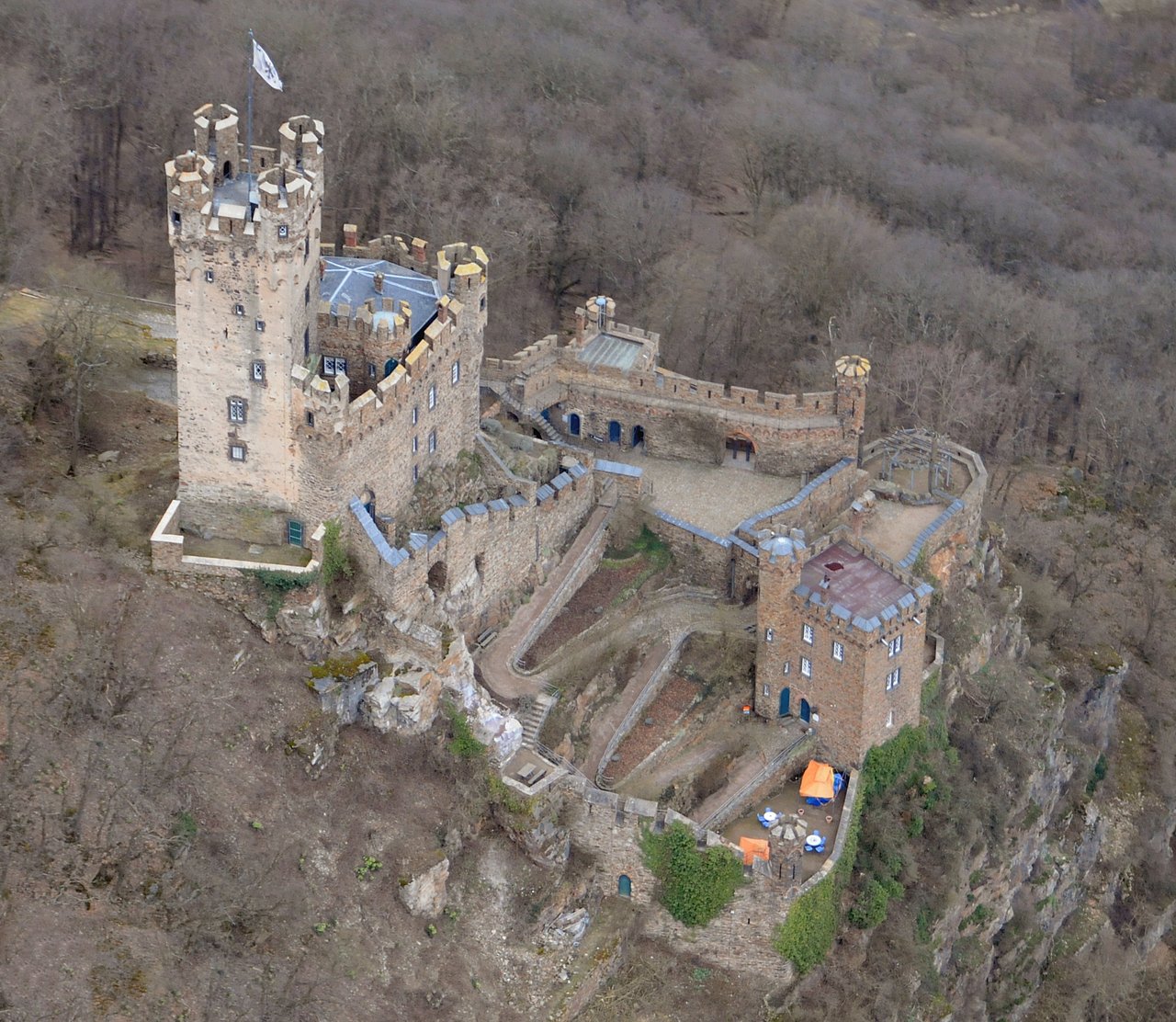 Castles of the Rhine Gorge 3 Direct overhead aerial view of Sooneck Castle showing the square Bergfried with four corner Eckwarten, the attached Wohnbau, the connecting curtain wall, the round Talturm in the Vorburg, and the stepped rose-terrace platforms.