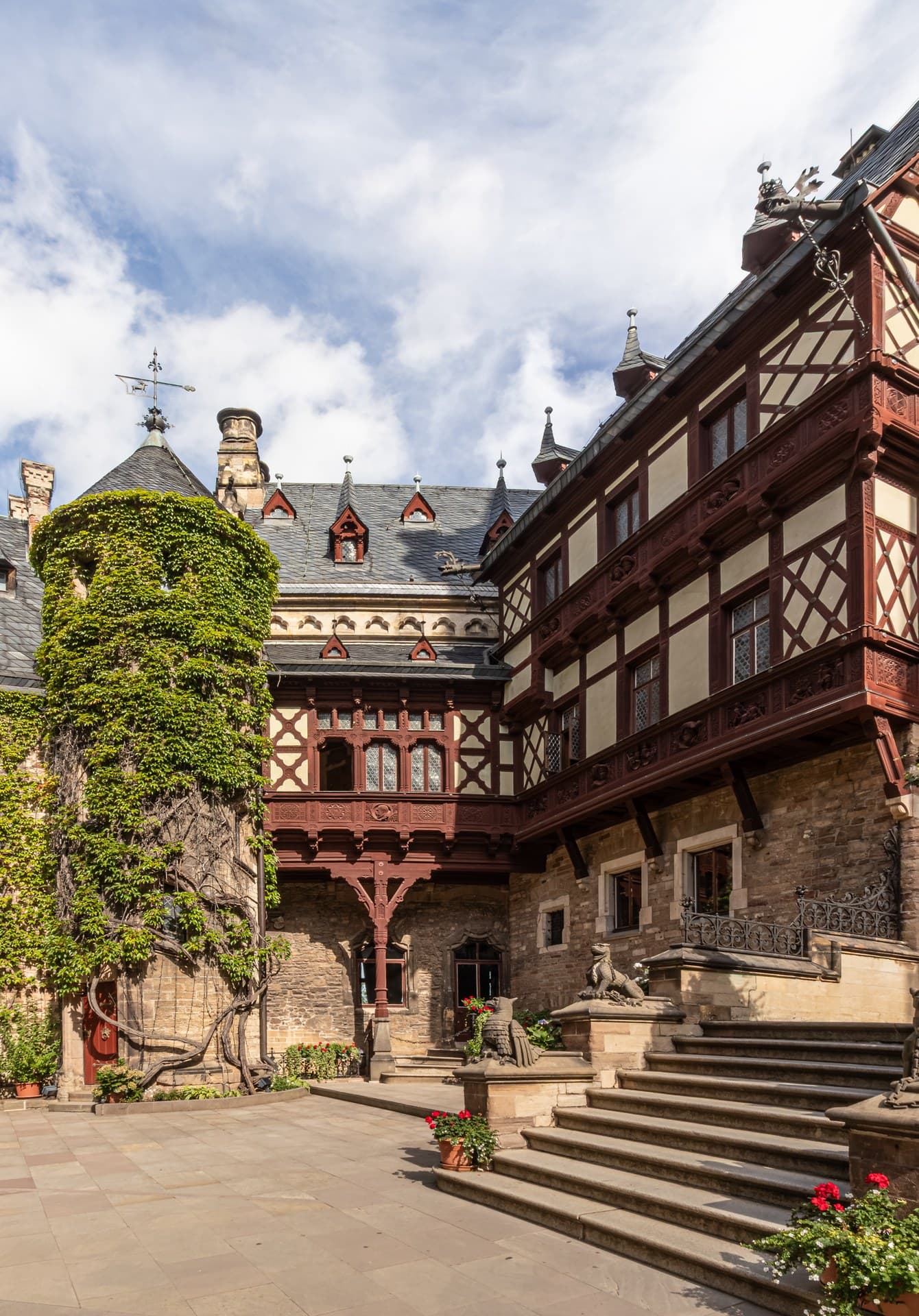 Wernigerode Castle 4 Inner Schlosshof of Wernigerode Castle showing ivy-clad stone tower, half-timber oriel bay window, and griffin-flanked stair