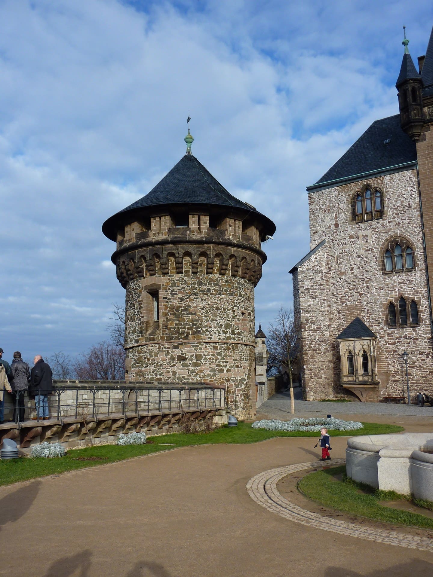 Wernigerode Castle 2 Round stone defensive tower (Wasserturm) at Wernigerode Castle, with the historicist palace beyond, viewed from the outer Schlossplatz terrace