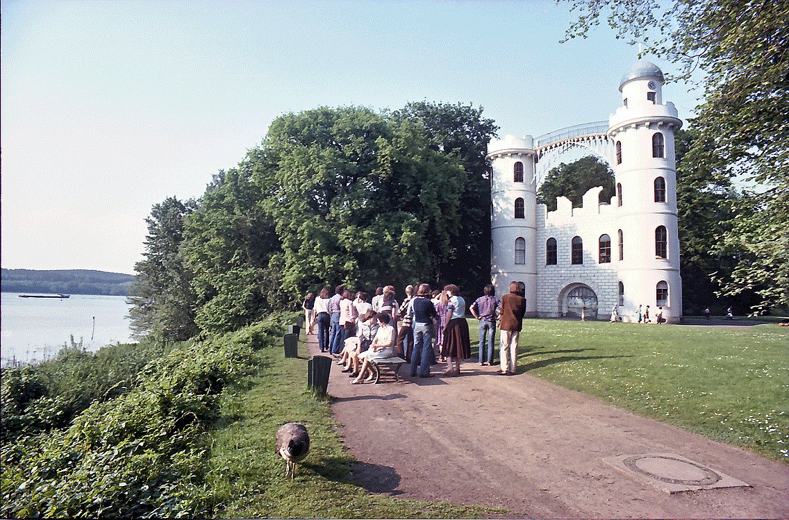 Pfaueninsel Palace 6 Visitors and a peacock on Pfaueninsel, with the palace beyond (historic photograph)
