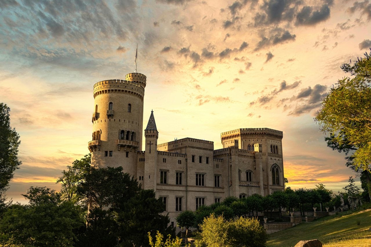 Babelsberg Palace 1 Babelsberg Palace at sunset, its round stair tower and English-Gothic garden front lit by golden evening light.