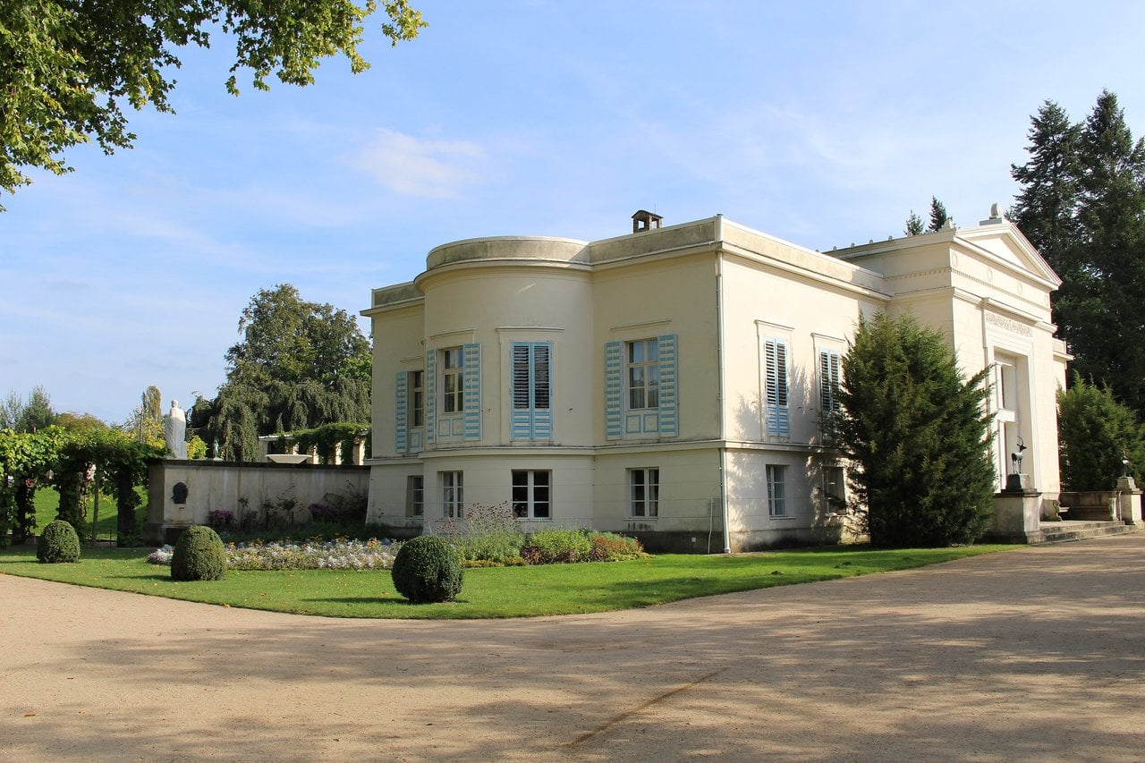 The Garden Palaces of Potsdam 4 The neoclassical villa of Charlottenhof Palace with its Doric portico and blue shutters.