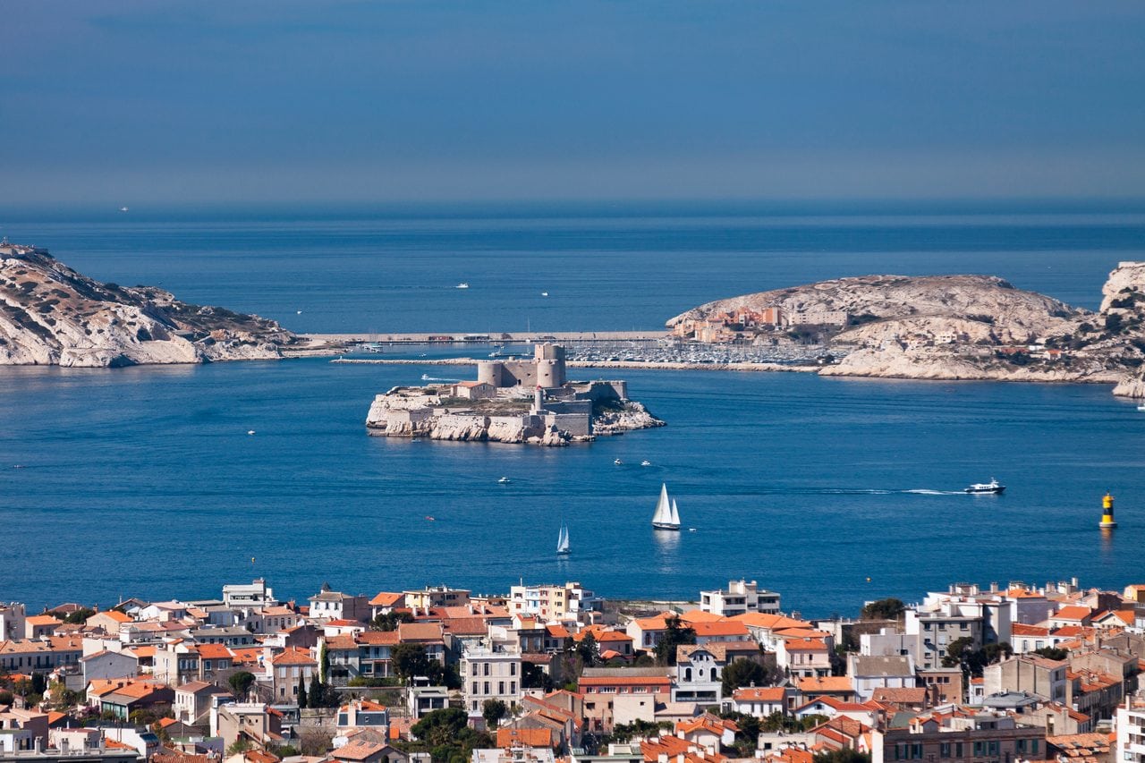 Aerial view of Château d'If on its island off Marseille, with the city and the Frioul archipelago beyond.