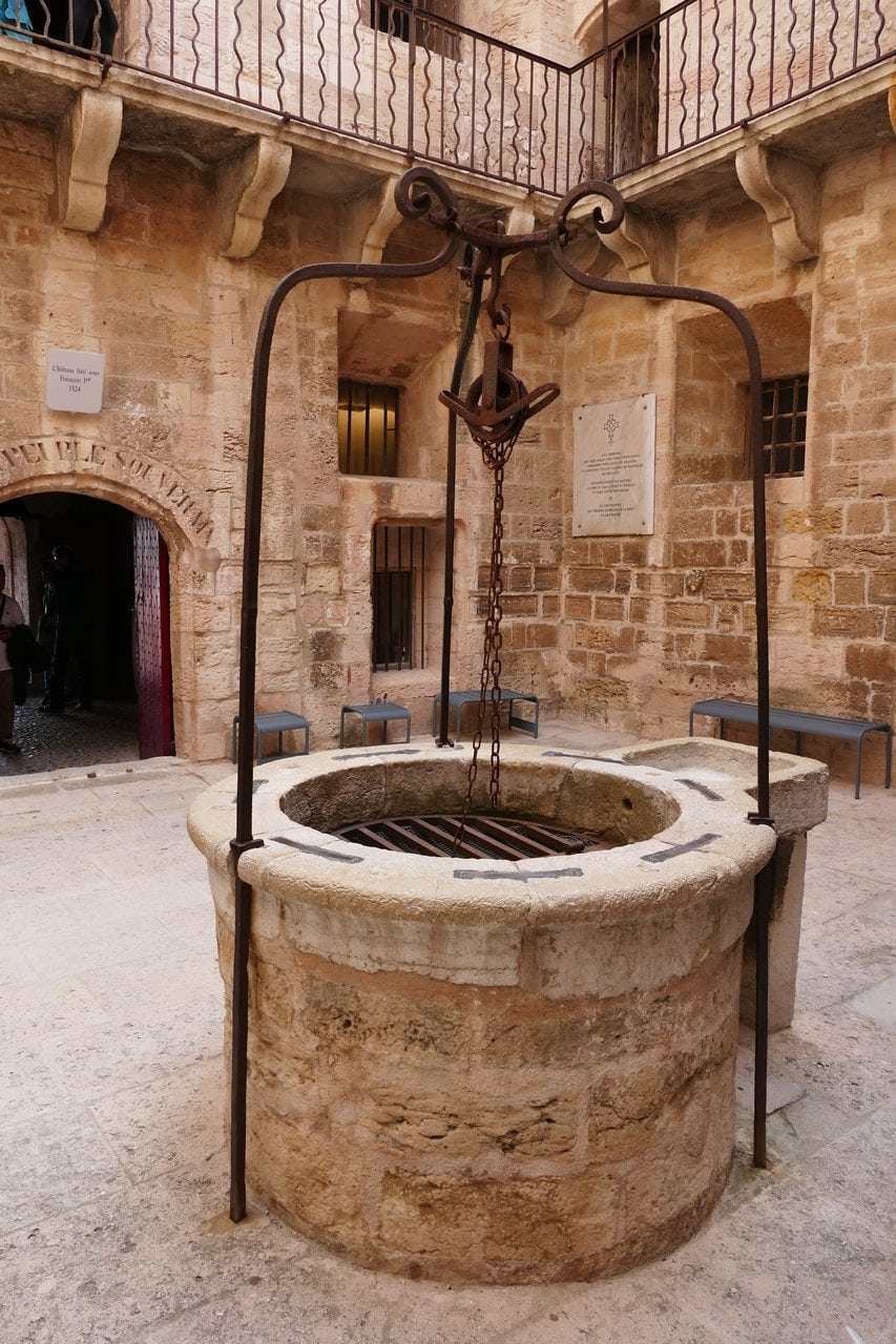 Stone well in the courtyard of Château d'If beneath the François I plaque.