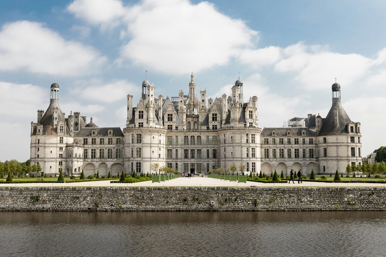 Châteaux of the Loire Valley: Nine Royal Houses 1 Chateau de Chambord north front reflected in water under a blue sky