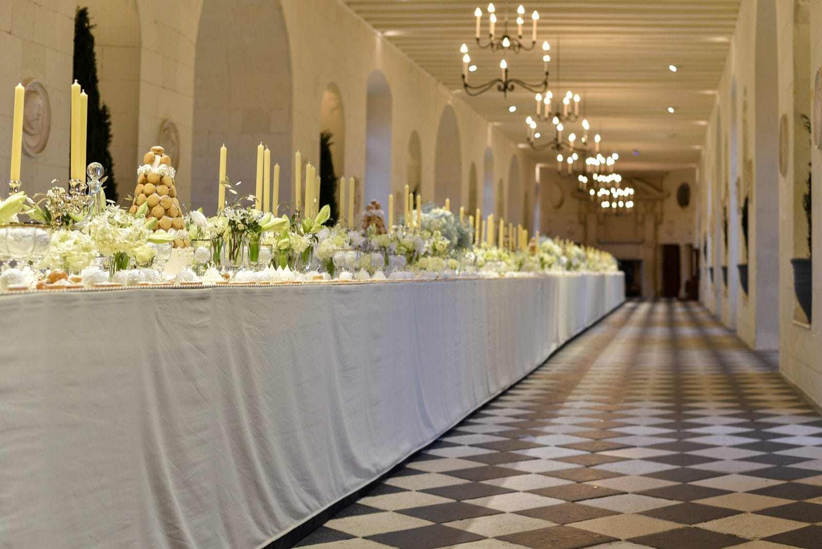 Banquet laid in the gallery — Antoine Montulé, CC BY-SA 4.0 The gallery of Chateau de Chenonceau laid with a long candlelit banquet table