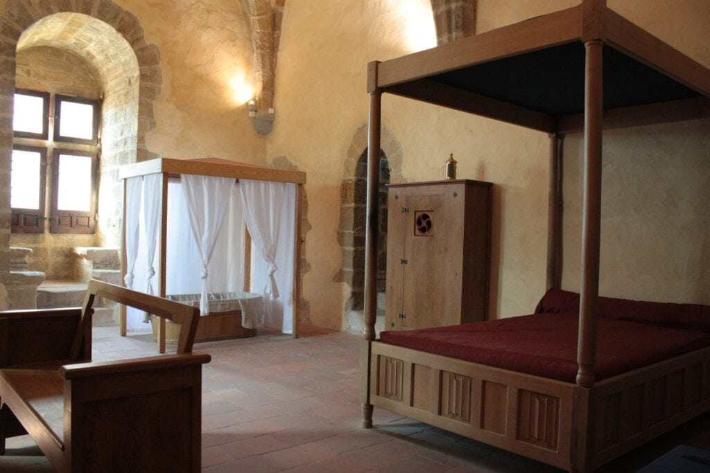 Château de Foix 6 A furnished medieval chamber with a curtained bed and cradle at Château de Foix