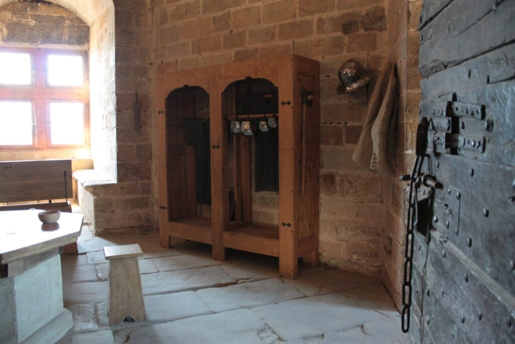 Château de Foix 7 The guards' room in the keep of Château de Foix, with a helmet and ironbound door