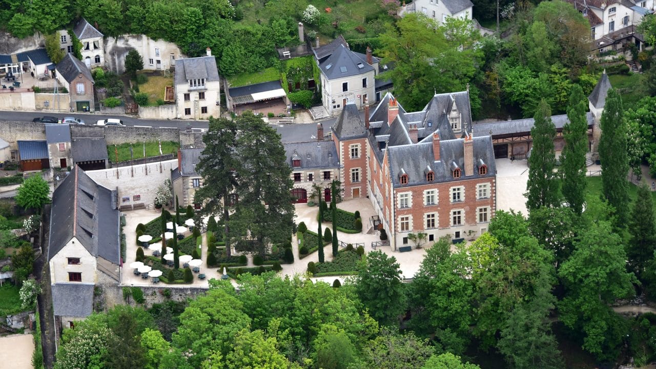 Château du Clos Lucé 6 Aerial view of Château du Clos Lucé with its gardens, gallery wing, and the troglodyte street above