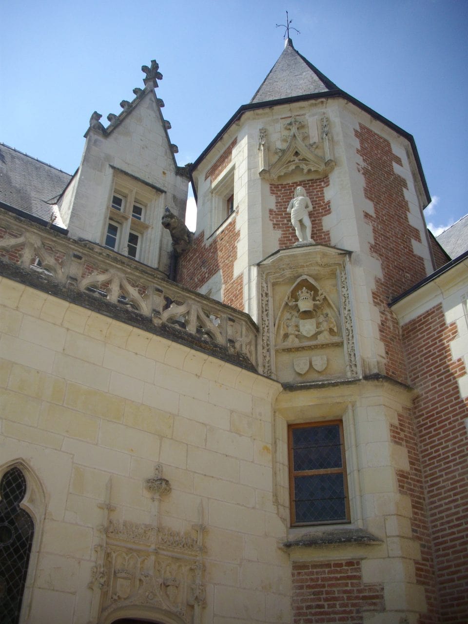 The watchtower and its statue niche — Fab5669, CC BY-SA 4.0 Watchtower of Clos Lucé with statue niche and carved arms above the chapel corner