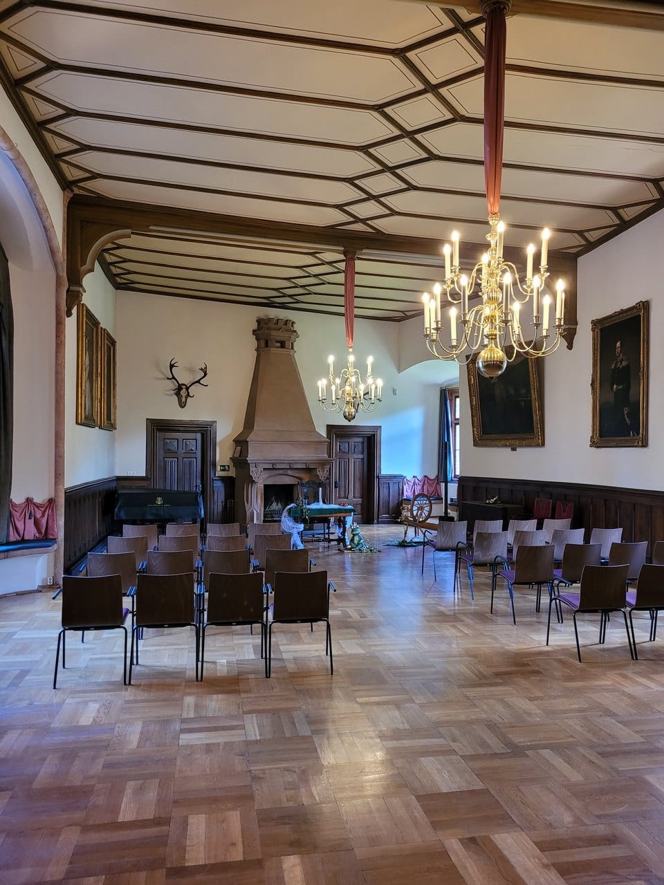 The neo-Gothic Great Hall of Kriebstein Castle with fireplace and chandeliers