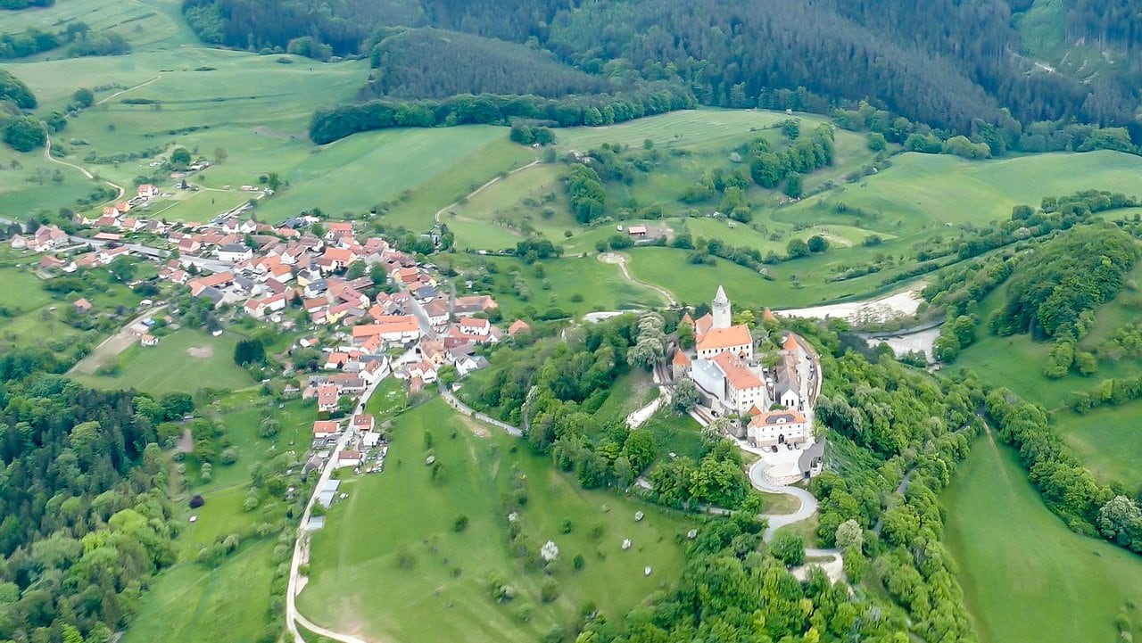 Aerial view above Seitenroda — Photo: NoRud, CC BY-SA 4.0, via Wikimedia Commons Aerial view of Leuchtenburg Castle on its hill above the village of Seitenroda near Kahla