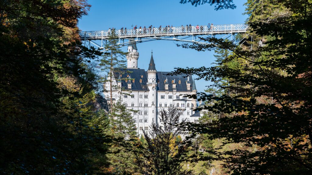 Neuschwanstein Castle 16 Neuschwanstein Castle viewed past the Marienbrücke, the iron footbridge spanning the Pöllat Gorge with visitors on it