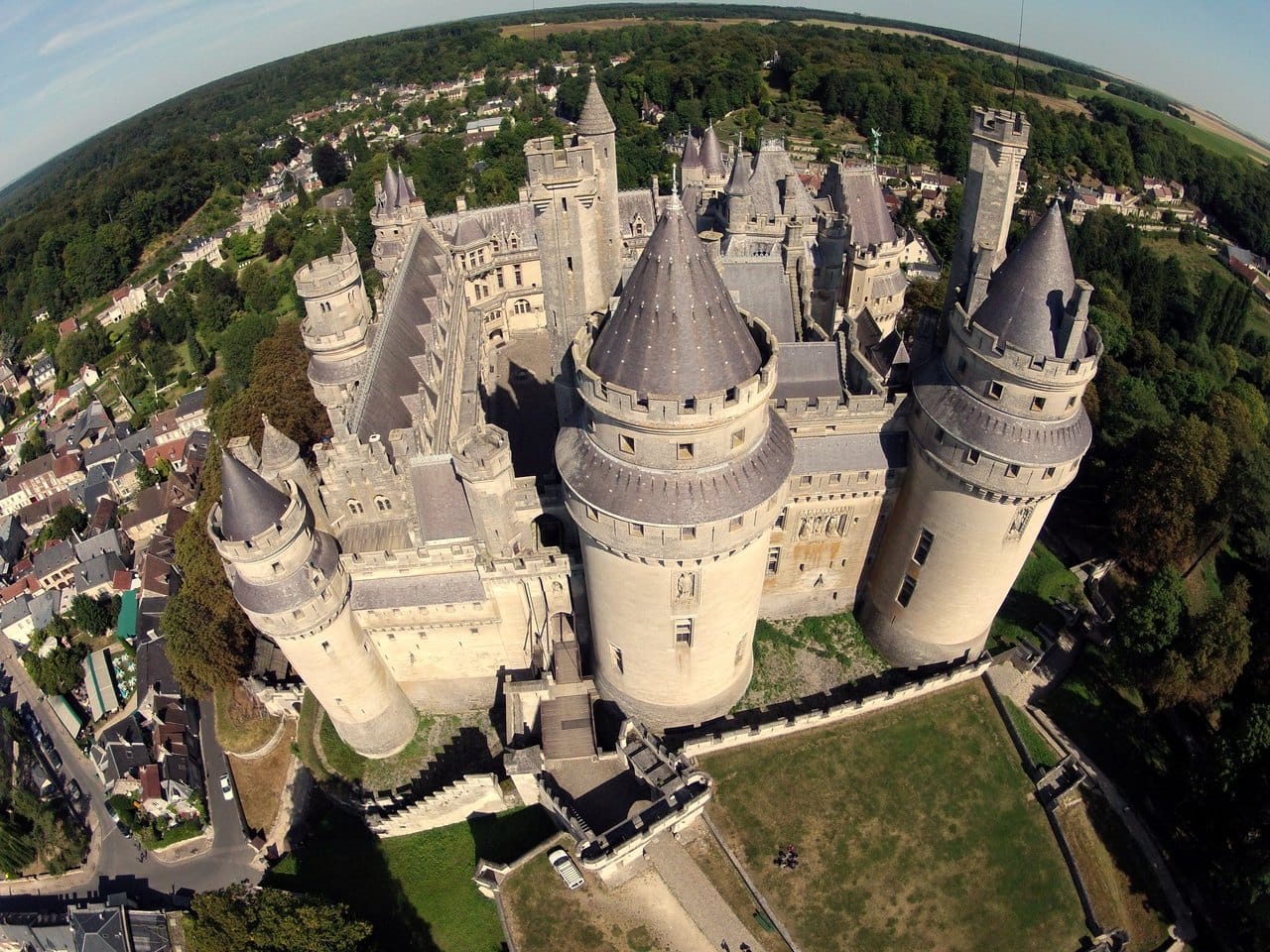 Pierrefonds from the air — ToucanWings, CC BY-SA 3.0 Fisheye aerial view of Pierrefonds showing the full ring of towers and the village below