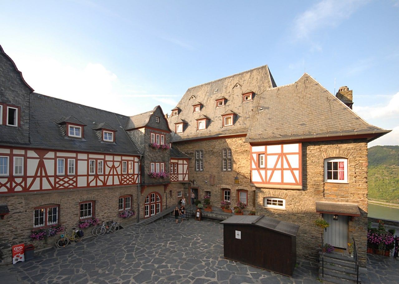 The courtyard at evening — Harald Nachtigall, CC BY-SA 3.0 The half-timbered courtyard ranges of Stahleck Castle in evening light.