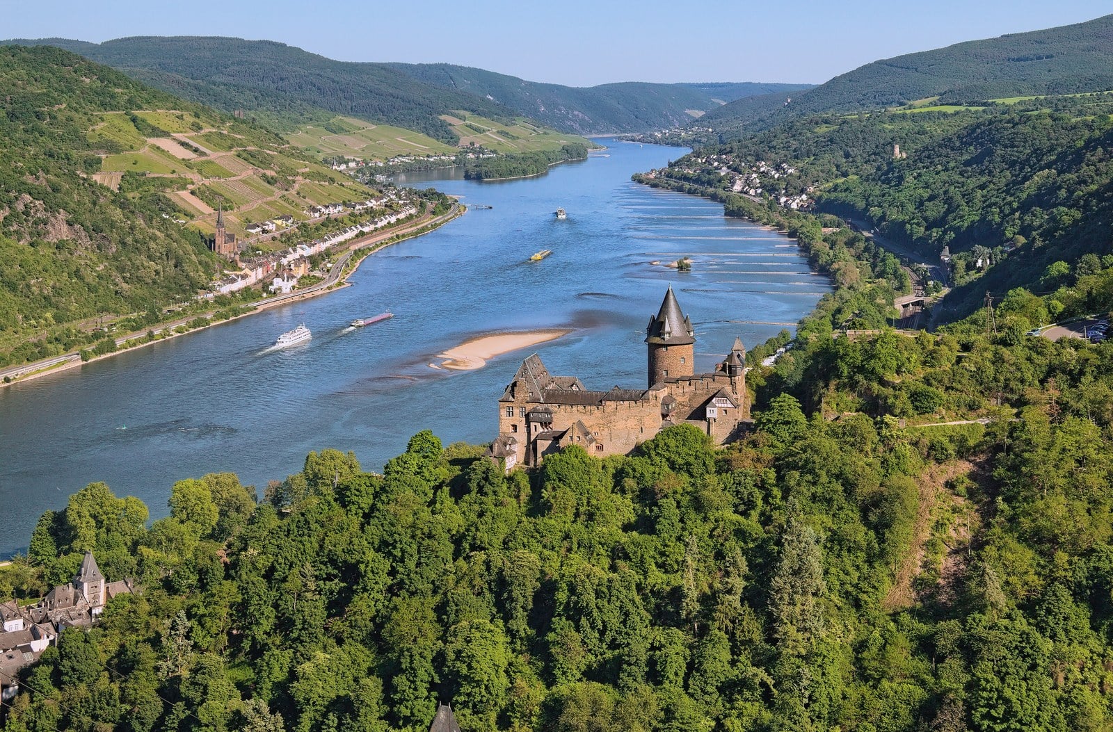 Stahleck Castle 1 Aerial view of Stahleck Castle on its wooded spur above Bacharach, the Rhine winding through the gorge beyond.