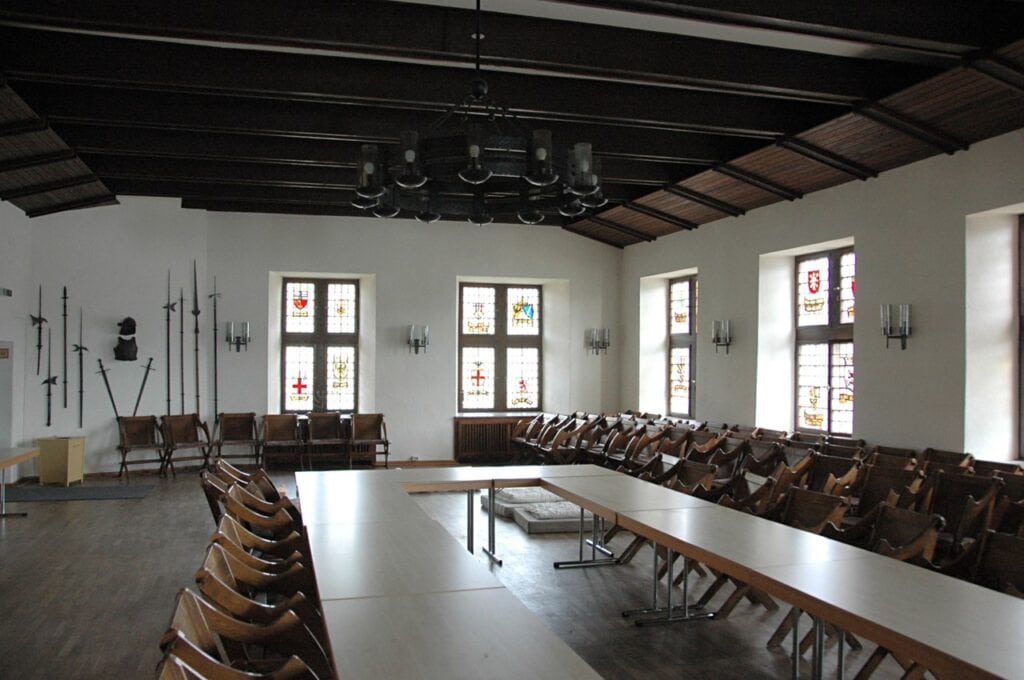 The Rittersaal (knights' hall) of Stahleck Castle with heraldic stained glass.