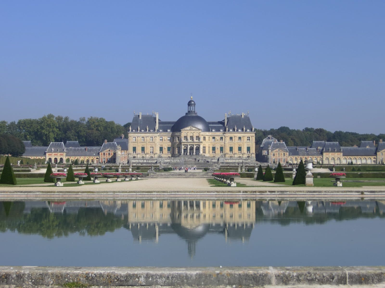 The garden front of the Chateau de Vaux-le-Vicomte with its dome mirrored in the basin