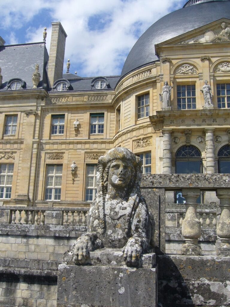A garden sphinx before the dome of Vaux-le-Vicomte