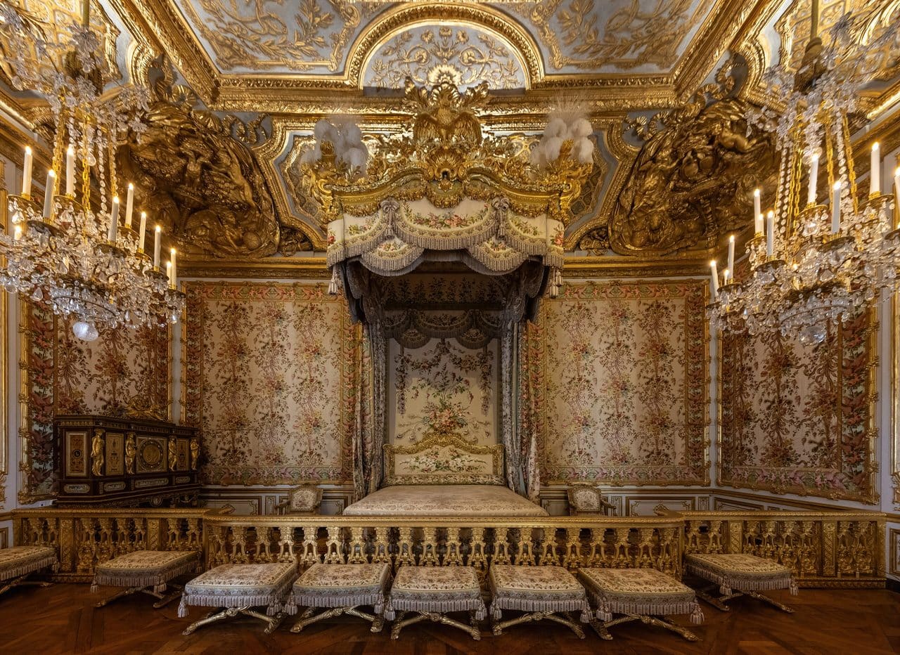 Palace of Versailles 6 The Queen's Bedchamber at Versailles, with patterned wall fabric, a canopied bed, and a gilded ceiling