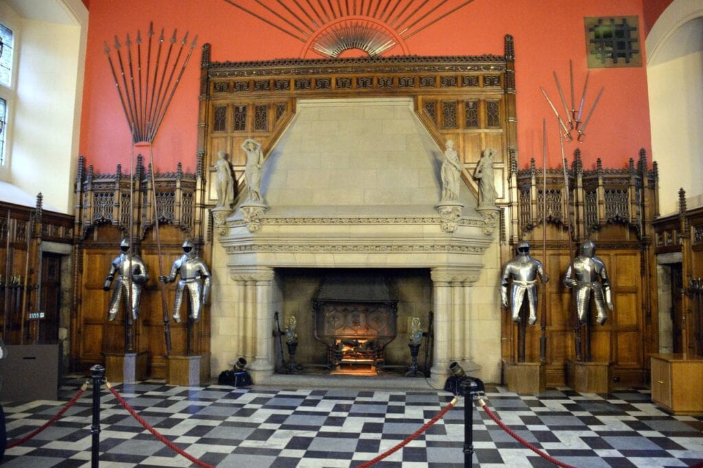 Edinburgh Castle 4 Suits of armor and fans of polearms line the Great Hall of Edinburgh Castle, its carved stone fireplace set into the wall at the far end.