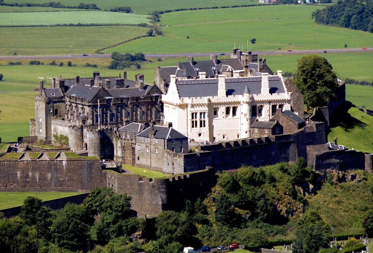 An aerial view shows the whole royal citadel packed onto its crag, the golden Great Hall and gray palace ranges rising above the curtain wall. An aerial view shows the whole royal citadel packed onto its crag, the golden Great Hall and gray palace ranges rising above the curtain wall.