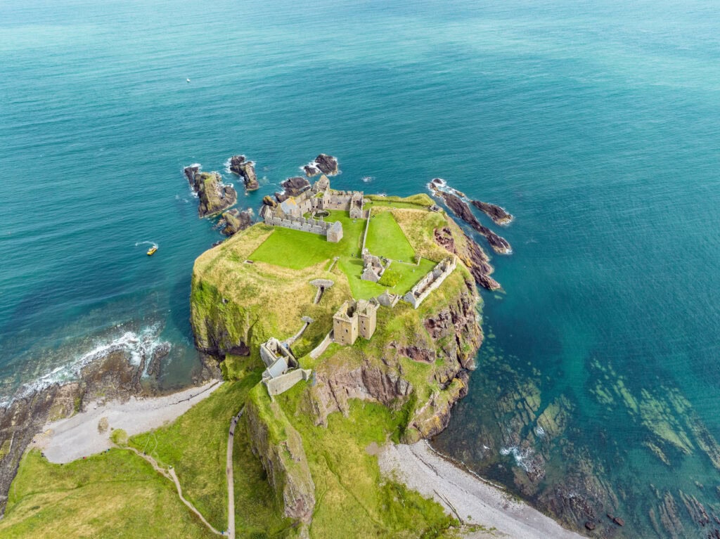 Dunnottar Castle 3 Dunnottar Castle seen from directly above, filling its flat-topped rock joined to the mainland by a single path.